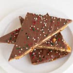 saltine cracker candy triangles on a white plate on a white surface