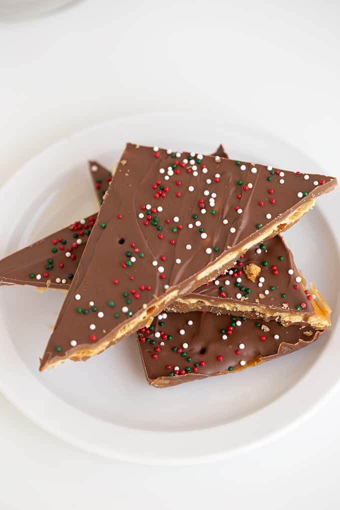 saltine cracker candy triangles on a white plate on a white surface