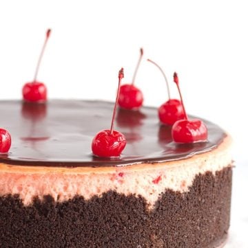 A cherry chocolate chip cheesecake with cherries on top.