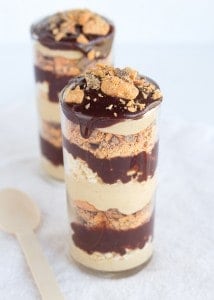 Chocolate peanut butter crunch trifle in a jar with a spoon.