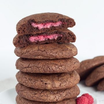 A stack of raspberry-filled fudge cookies on a plate.