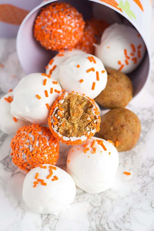 cake pops spilling out of bucket onto a marbled surface with a center showing of a cake pop