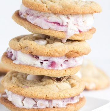 A stack of raspberry froyo cookie sandwiches on a white plate.