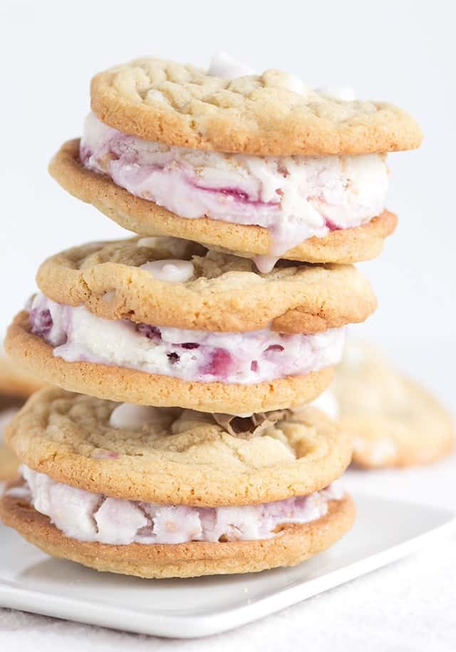 A stack of raspberry froyo cookie sandwiches on a white plate.