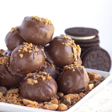 Chocolate covered Butterfinger Bites Oreos on a plate.