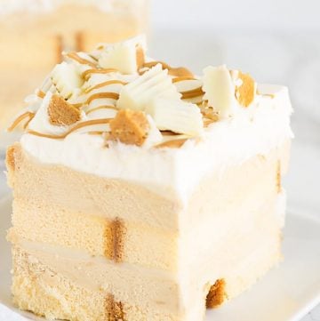 A no-bake, peanut butter dessert topped with white chocolate served on a white plate.