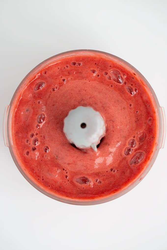 overhead image of strawberry puree being made in a food processor