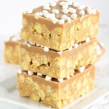 No Bake Peanut Butter Cereal Bars stacked on a plate.