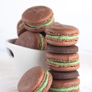 A stack of Thin Mint chocolate macarons with green frosting.