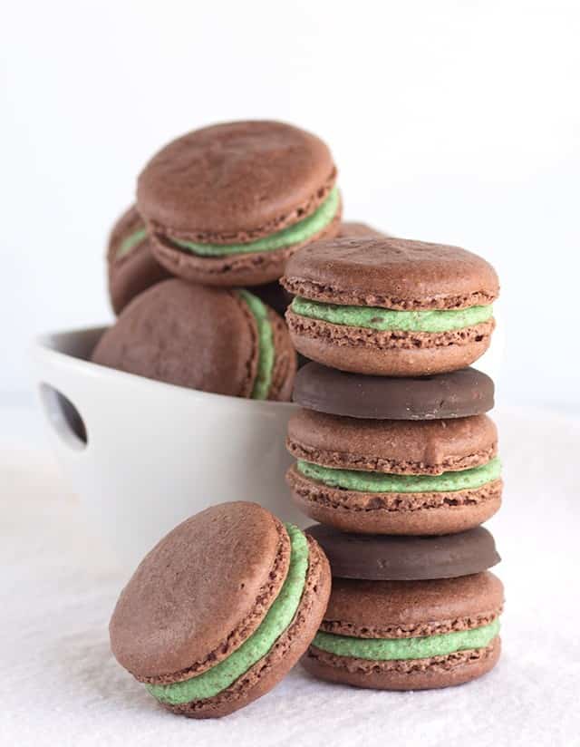 A stack of Thin Mint chocolate macarons with green frosting.