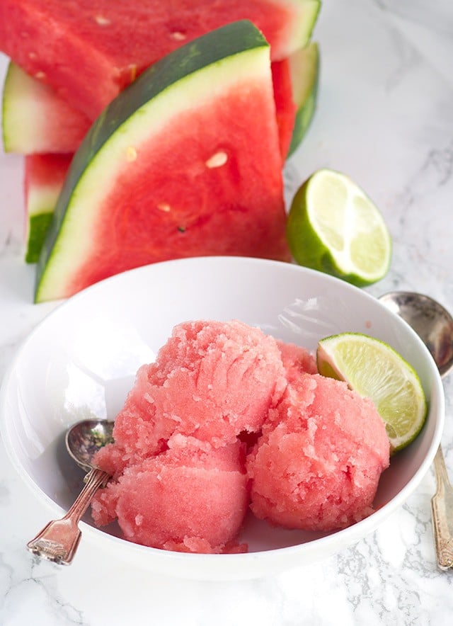 overhead image of a bowl of Watermelon Sorbet next to fresh watermelon slices
