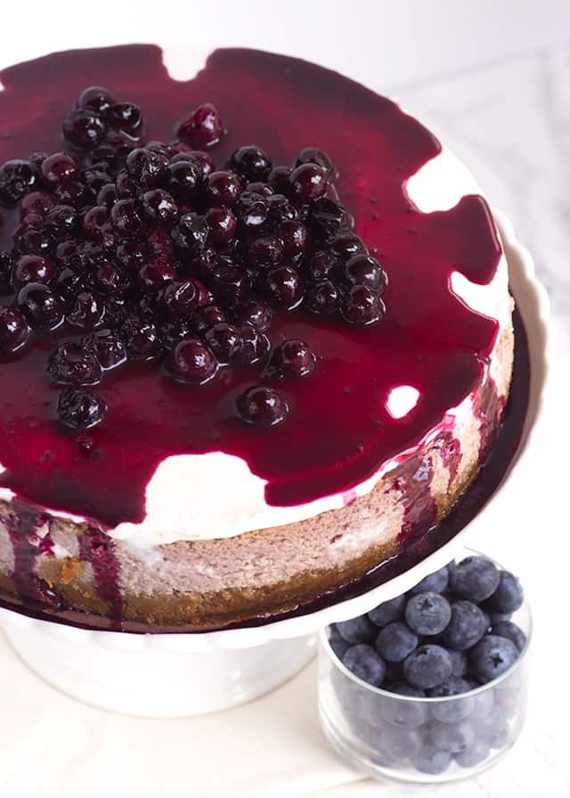 A blueberry cheesecake topped with fresh blueberries.