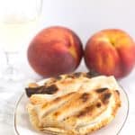 A grilled peach pie paired with a glass of wine.