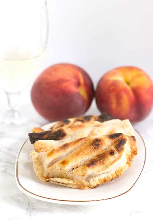 A grilled peach pie paired with a glass of wine.