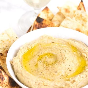 A plate of grilled tortilla chips and hummus, perfect for a satisfying snack.