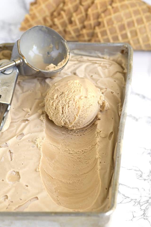 Sweet tea ice cream in a pan being scooped out with a ice cream scoop