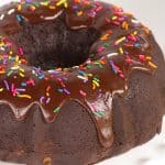 A chocolate bundt cake with chocolate icing and sprinkles, ideal for fans of chocolate and indulgence.