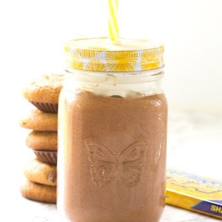 Chocolate peanut butter milkshake in a mason jar with a yellow straw.