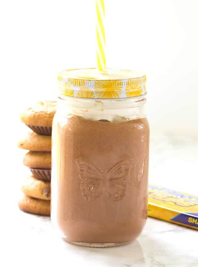 Chocolate peanut butter milkshake in a mason jar with a yellow straw.