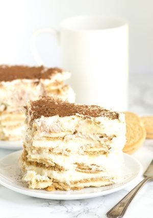 A slice of Oreo tiramisu on a plate with a cup of coffee.