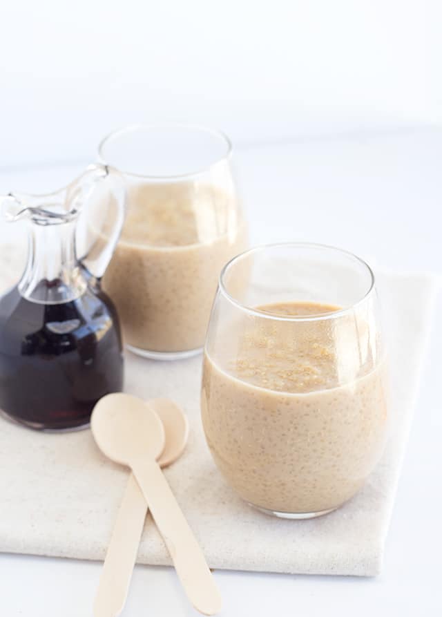 Two glasses of Maple Peanut Butter pudding with spoons on a table.