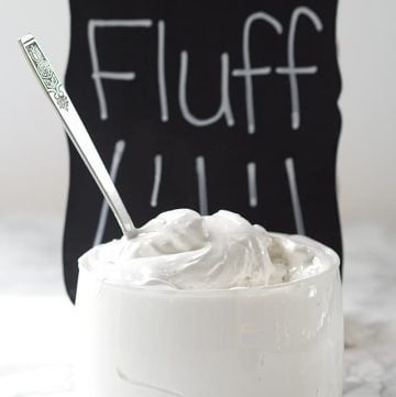 A bowl of Homemade Marshmallow Fluff in front of a chalkboard.