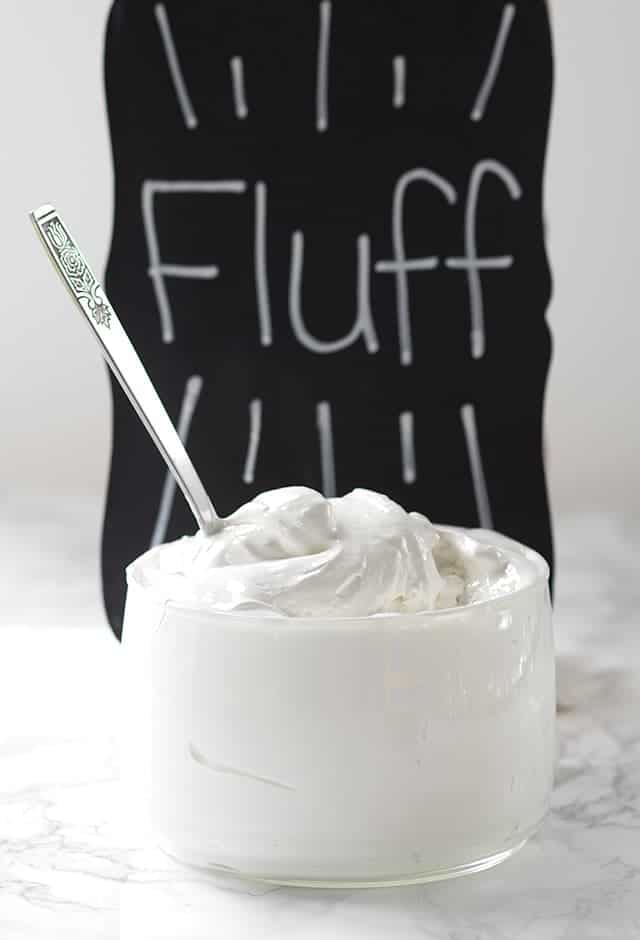 A bowl of Homemade Marshmallow Fluff in front of a chalkboard.