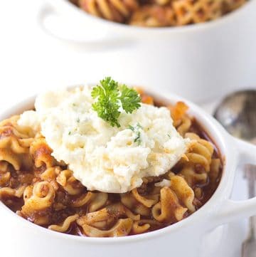 A savory lasagna soup recipe served in two white bowls.