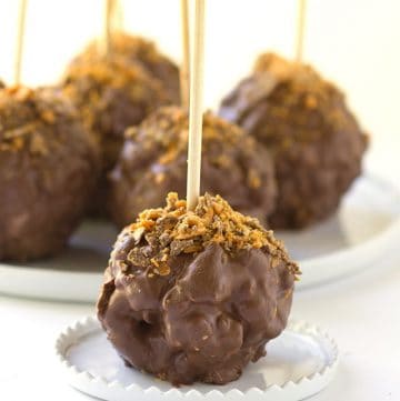 Chocolate Covered Peanut Butter Popcorn Balls - gooey peanut butter marshmallow popcorn balls coated with chocolate and sprinkled with butterfinger bits!