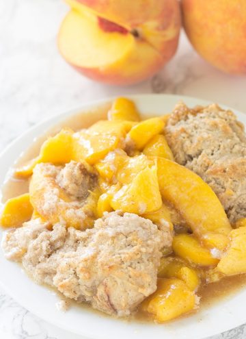 Skillet Peach Cobbler - fresh peaches sliced thrown in a skillet and topped with the perfect biscuit. This tastes amazing warmed with a scoop of vanilla ice cream!