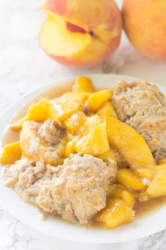 Skillet Peach Cobbler - fresh peaches sliced thrown in a skillet and topped with the perfect biscuit. This tastes amazing warmed with a scoop of vanilla ice cream!