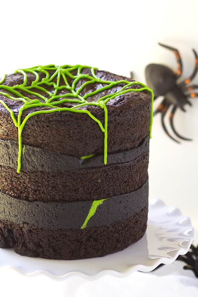 A Spider Egg Brownie Cake with green frosting and spiders on top.
