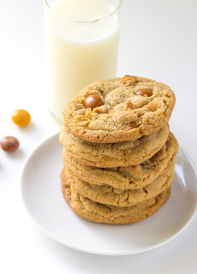 a plate with a stack of chewy homemade cookies loaded with butterscotch chips and butterscotch m&ms.