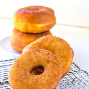 Three potato donuts sitting on a cooling rack.