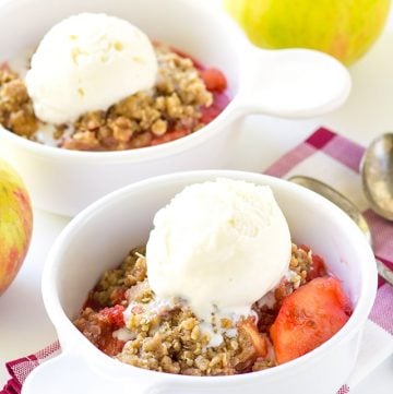 Two bowls of Crock Pot apple crisp with ice cream and apples.