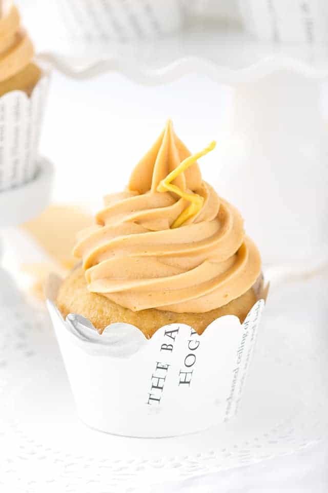 A Butterbeer cupcake with a lemon buttercream frosting on a white plate.