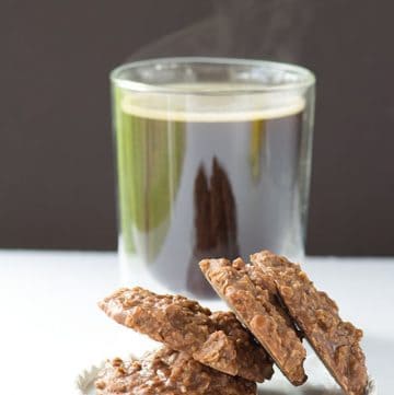 A plate of No Bake Cookies next to a cup of coffee.