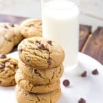 thick soft peanut butter chocolate chip cookies next to a glass of milk