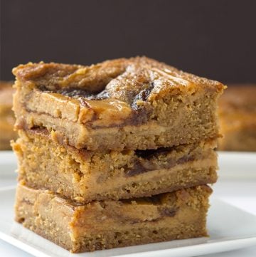 A stack of peanut butter bars on a white plate.