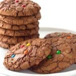 A stack of brownie cookies topped with M&M's.