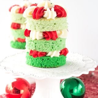 A stack of Christmas tree cakes on a white plate.
