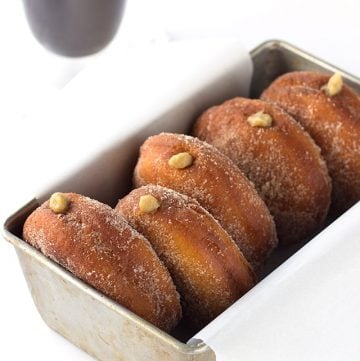 Cinnamon sugar donuts in a pan with a cup of coffee.