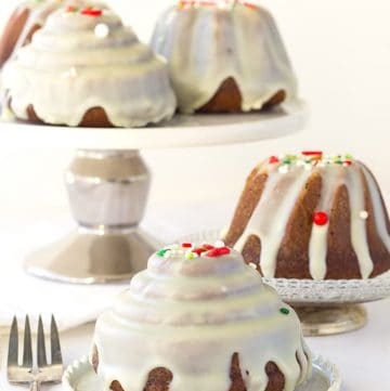 Three gingerbread bundt cakes with icing and sprinkles on top.