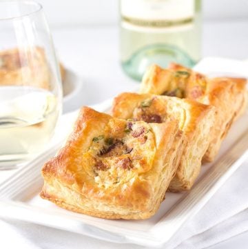 A glass of white wine paired with Jalapeno Popper Bites appetizers.