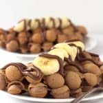 A plate of Nutella bubble waffles topped with bananas.