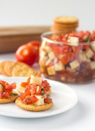 Caprese Salsa - finely diced tomatoes, shallots, basil and mozzarella tossed in a balsamic glaze and scooped up with some buttery ritz crackers!