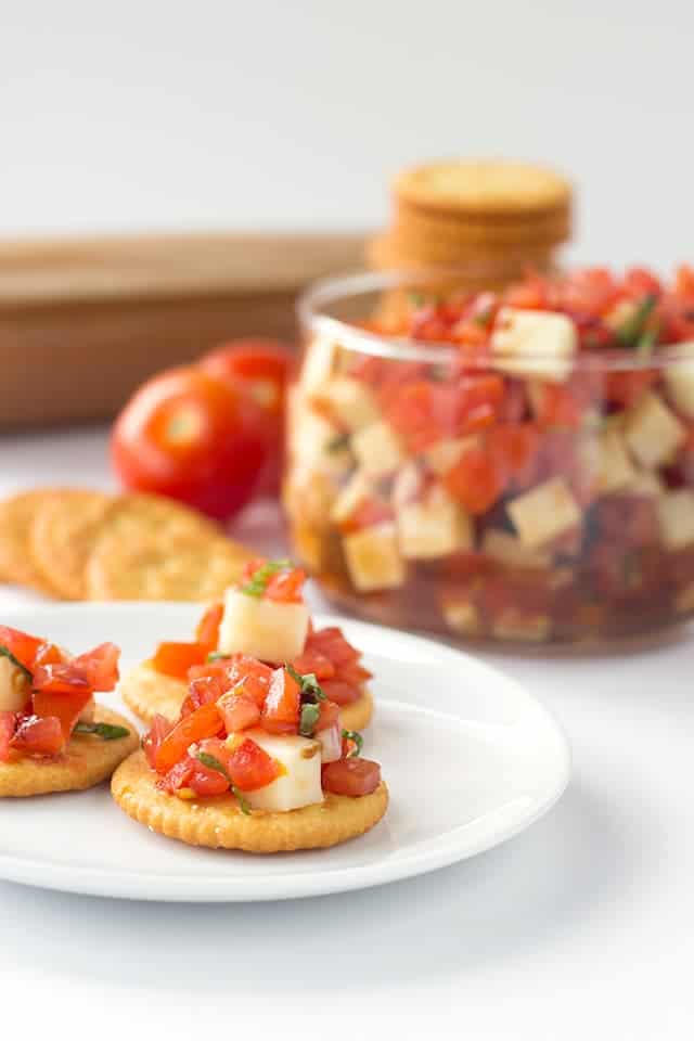 Caprese Salsa - finely diced tomatoes, shallots, basil and mozzarella tossed in a balsamic glaze and scooped up with some buttery ritz crackers!