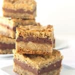 A stack of delectable chocolate peanut butter oatmeal bars on a white plate.