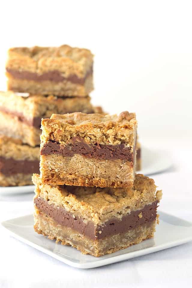 A stack of delectable chocolate peanut butter oatmeal bars on a white plate.
