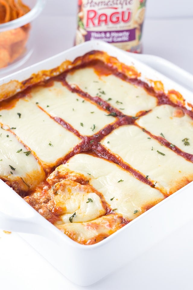 This lasagna dip recipe is a must make party dip. It's a hearty dip with 3 kinds of cheese and sausage and can be served with toasted baguette slices or chips! pan of warm and cheesy Lasagna Dip